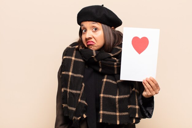 Young pretty woman holding a heart card