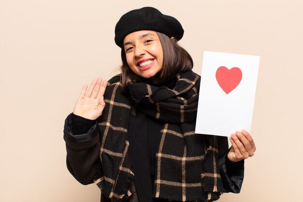 Young pretty woman holding a heart card