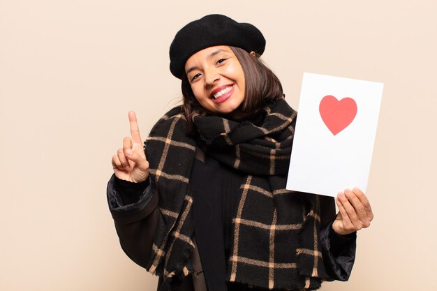 Young pretty woman holding a heart card