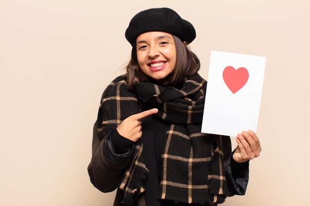 Young pretty woman holding a heart card