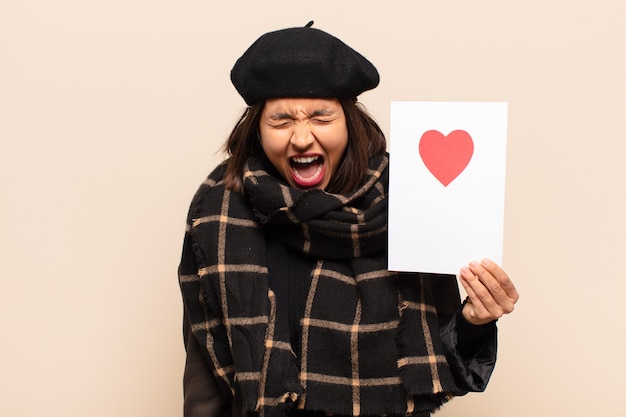 Young pretty woman holding a heart card