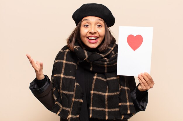 Young pretty woman holding a heart card