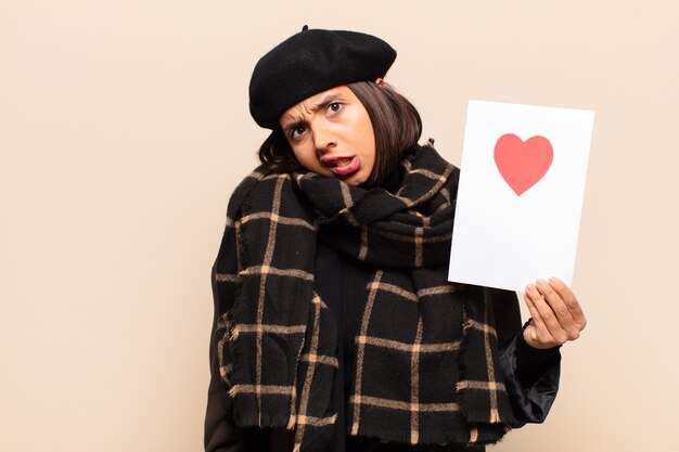 Young pretty woman holding a heart card