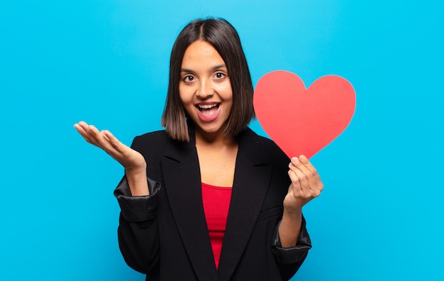 Young pretty woman holding a heart card