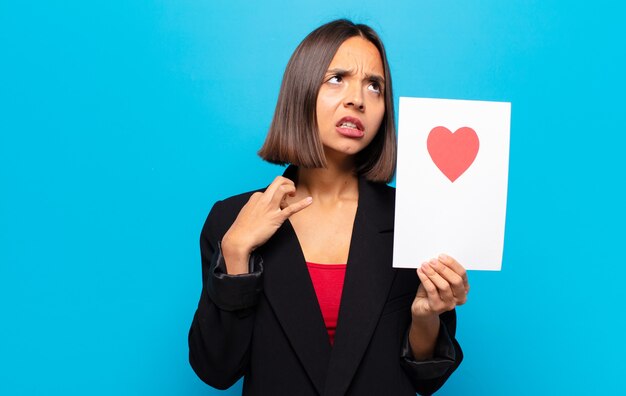 Young pretty woman holding a heart card