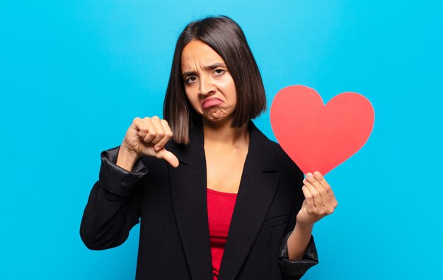 Photo young pretty woman holding a heart card