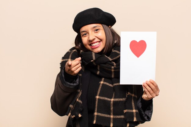 Young pretty woman holding a heart card