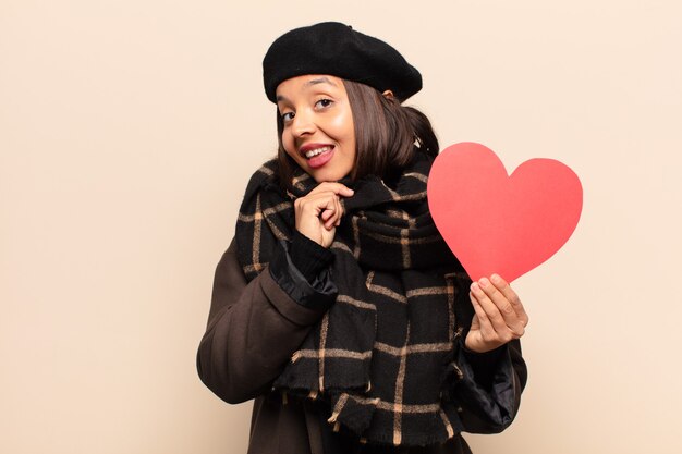 Young pretty woman holding a heart card