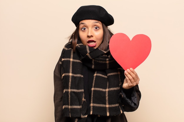 Young pretty woman holding a heart card