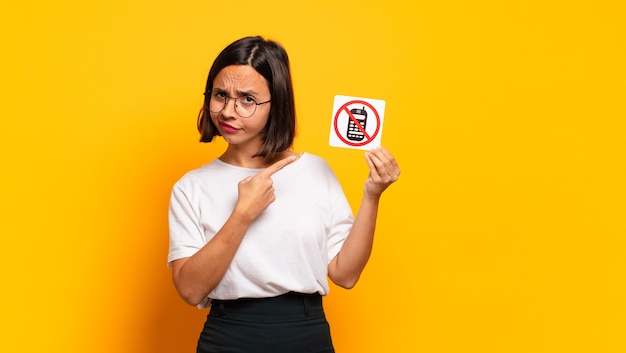 Young pretty woman holding no cell sign