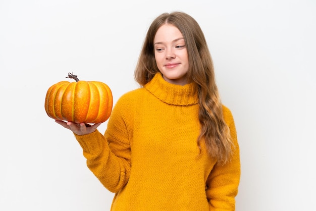 Young pretty woman holding a pumpkin isolated on white background with happy expression