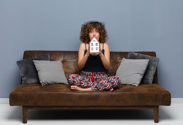 Young pretty woman at home and sitting on a sofa.