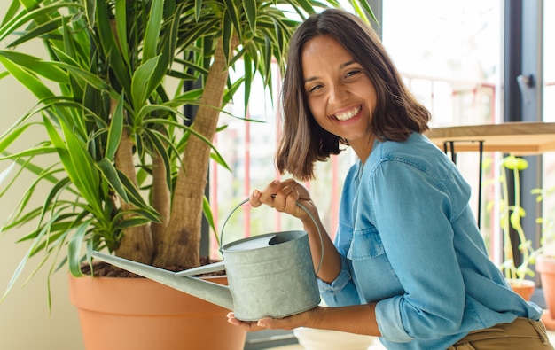 植物と家で若いきれいな女性