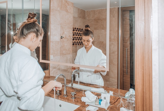 Young pretty woman is cleaning her teeth in the bathroom.