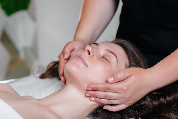 A young pretty woman is enjoying a professional head massage at the Spa