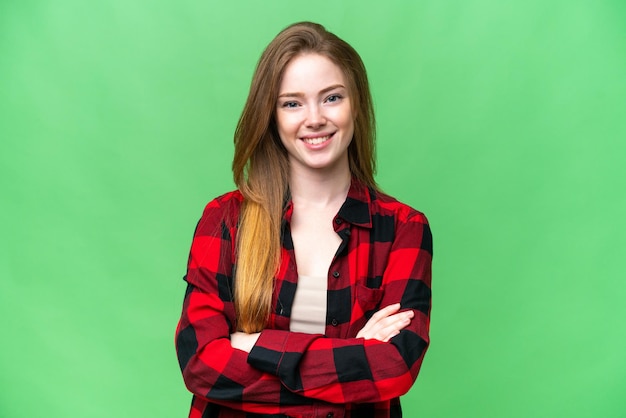 Young pretty woman over isolated chroma key background keeping the arms crossed in frontal position