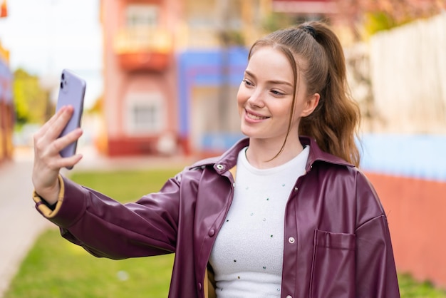 Young pretty woman over isolated chroma key background with surprise expression while pointing side