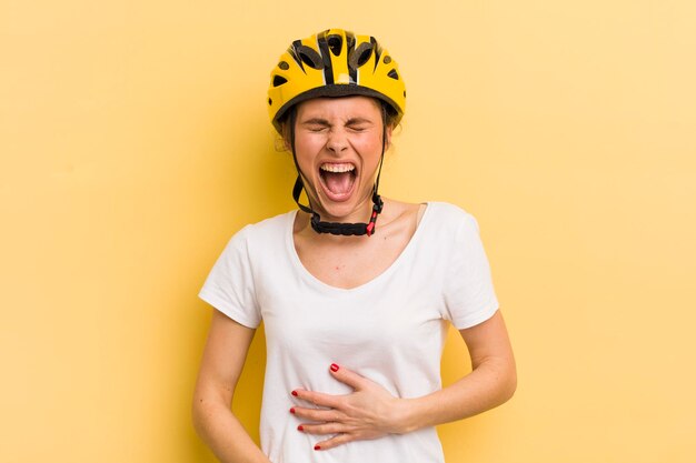 Молодая красивая женщина смеется вслух над какой-то веселой концепцией велосипеда шутки