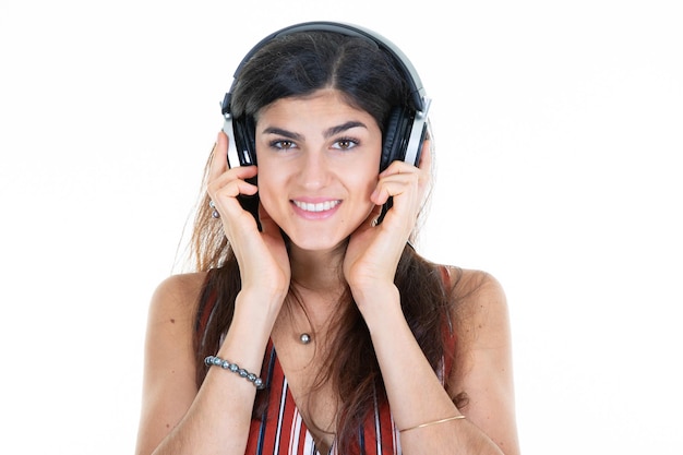 Young pretty woman listening to music in headphones on white background