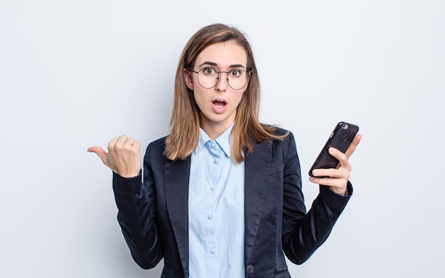 Young pretty woman looking astonished in disbelief business concept