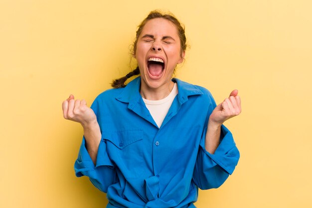 Young pretty woman looking extremely happy and surprised celebrating success shouting and jumping