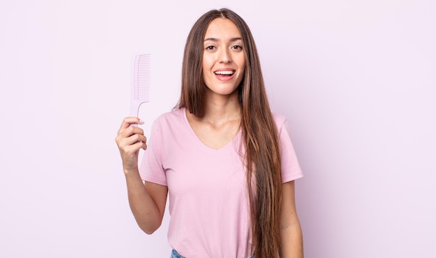 Young pretty woman looking happy and pleasantly surprised. hair comb concept