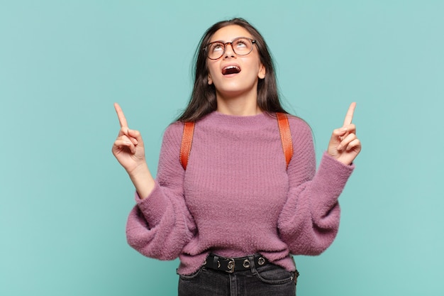 Young pretty woman looking shocked, amazed and open mouthed