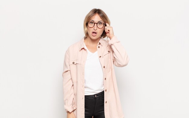 깜짝 찾고, 입을 벌리고, 충격을 찾고, 새로운 생각, 아이디어 또는 개념을 실현하는 젊은 예쁜 여자
