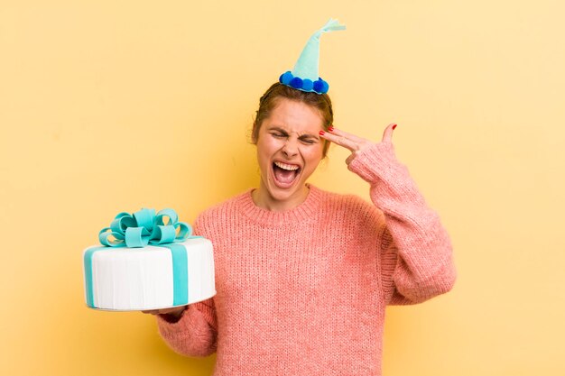 Young pretty woman looking unhappy and stressed suicide gesture\
making gun sign birthday concept