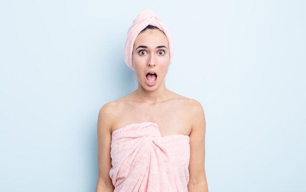 Young pretty woman looking very shocked or surprised. beauty and shower concept