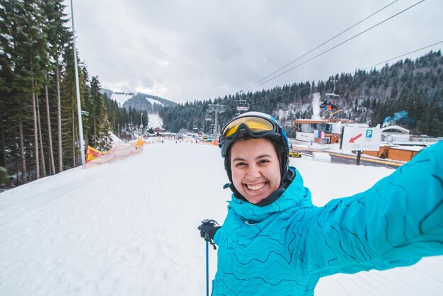 Photo young pretty woman making selfie while skiing