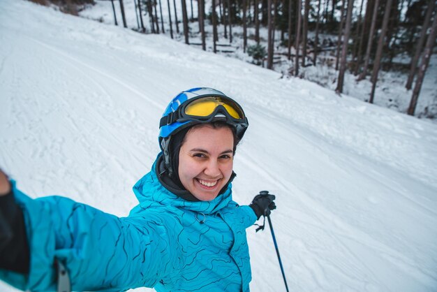 Photo young pretty woman making selfie while skiing