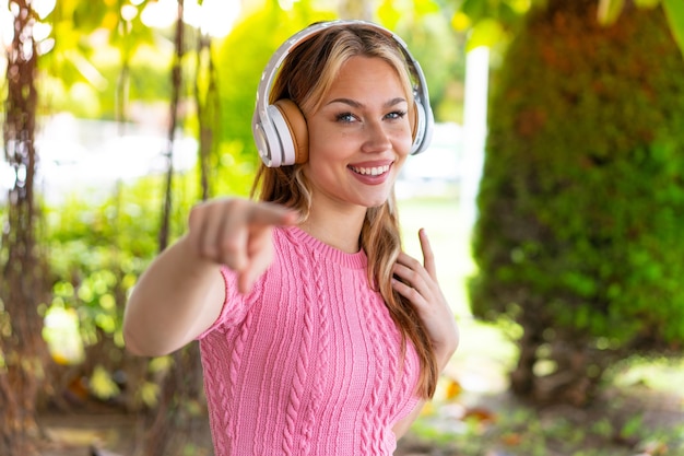 Young pretty woman at outdoors listening music