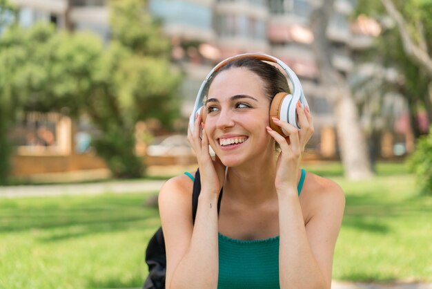 Photo young pretty woman at outdoors listening music