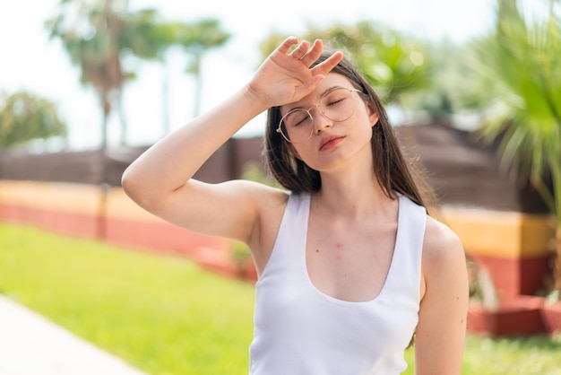 young pretty woman at outdoors with glasses and tired