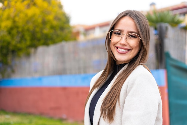 Giovane bella donna all'aperto con espressione felice