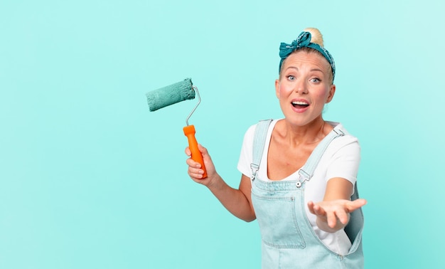 Young pretty woman painting a wall with a roller