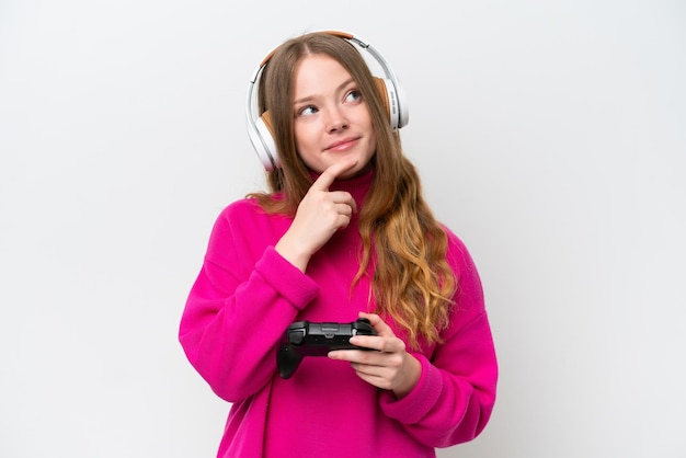 Young pretty woman playing with a video game controller isolated on white background and looking up