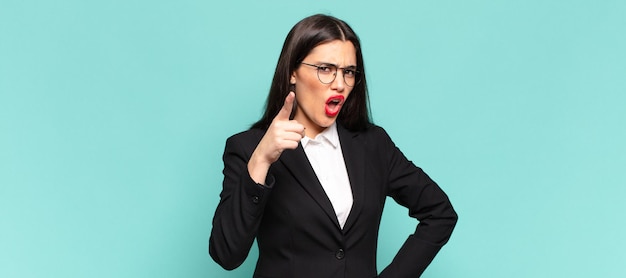 Young pretty woman pointing at camera with an angry aggressive expression looking like a furious crazy boss business concept