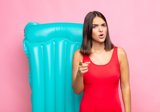 Young pretty woman pointing at camera with an angry aggressive expression looking like a furious, crazy boss