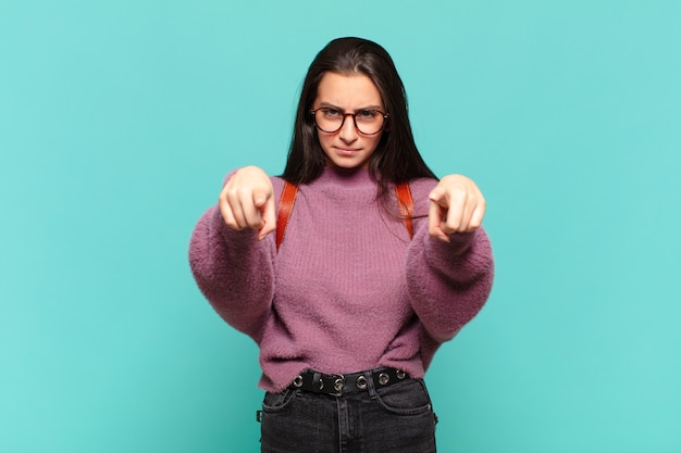 Young pretty woman pointing forward at front with both fingers and angry expression, telling you to do your duty