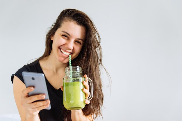 Photo young pretty woman portrait drink smoothie. white background. copy space