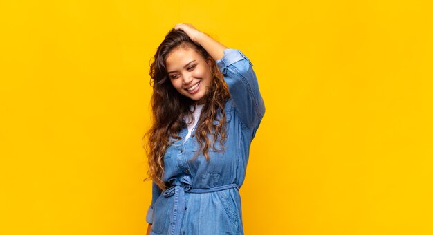 young pretty woman posing against the colored wall