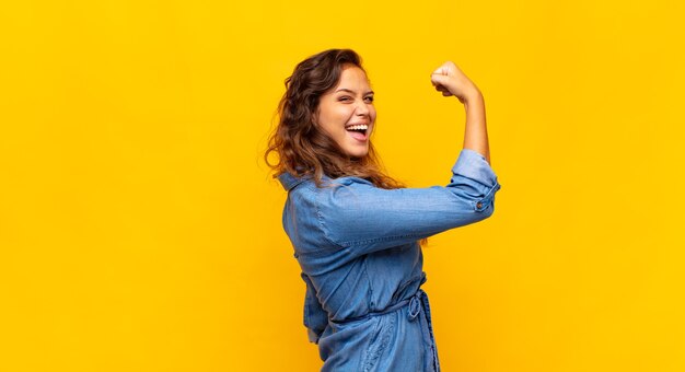 young pretty woman posing against the colored wall