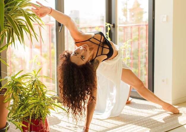 Young pretty woman practising yoga indoor.