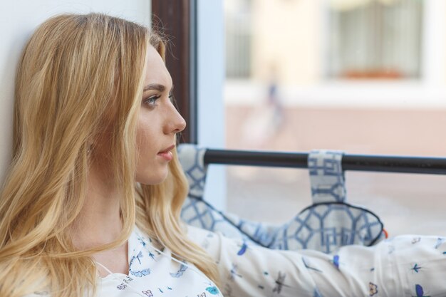 Young pretty woman resting in cafe and looking out the window