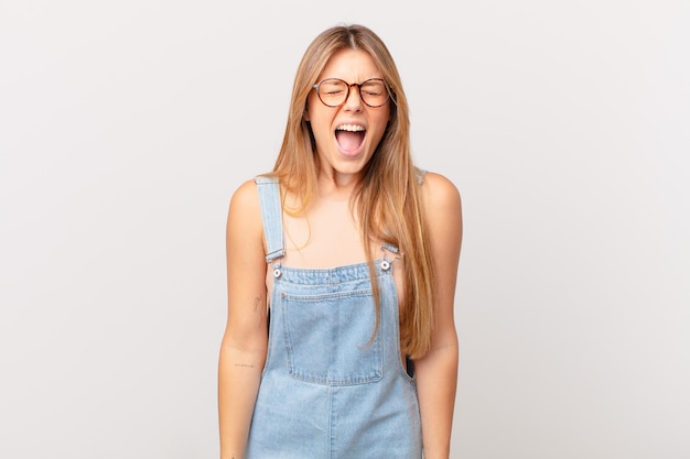 Young pretty woman shouting aggressively, looking very angry