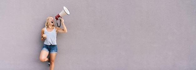 Photo young pretty woman shouting on a megaphone to demonstrat and fight for climate change. global warming and enviroment concept. fridays for future. copyspace for your individual text.