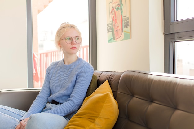 Young pretty woman sitting on a couch at home