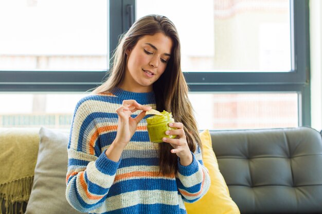 食べる革のソファに座っている若いきれいな女性